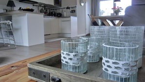 Una cocina moderna con armarios blancos, encimera de madera y una zona de comedor con banco.