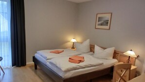 Una cama doble con dos mesitas de noche y un cuadro en la pared.