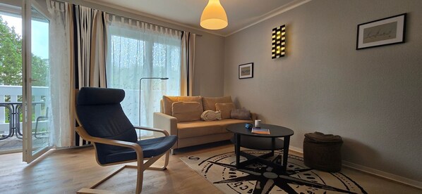 A living room with a sofa, a chair, a coffee table, and a rug.