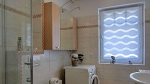A bathroom with a toilet, washing machine, and sink. - Vacation Rental K36 - Central 2-Bedroom Apartment for 3 People, Terrace (Graal-Müritz)