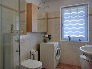Ein Badezimmer mit Toilette, Waschmaschine und Waschbecken.