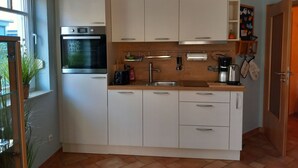 A modern kitchen with white cabinets, a built-in oven, and a sink.
