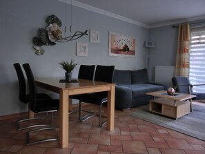 Un salon moderne comprenant une table à manger, des chaises, un canapé et une petite table basse.