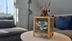 A small wooden table with a glass terrarium containing rocks and branches.