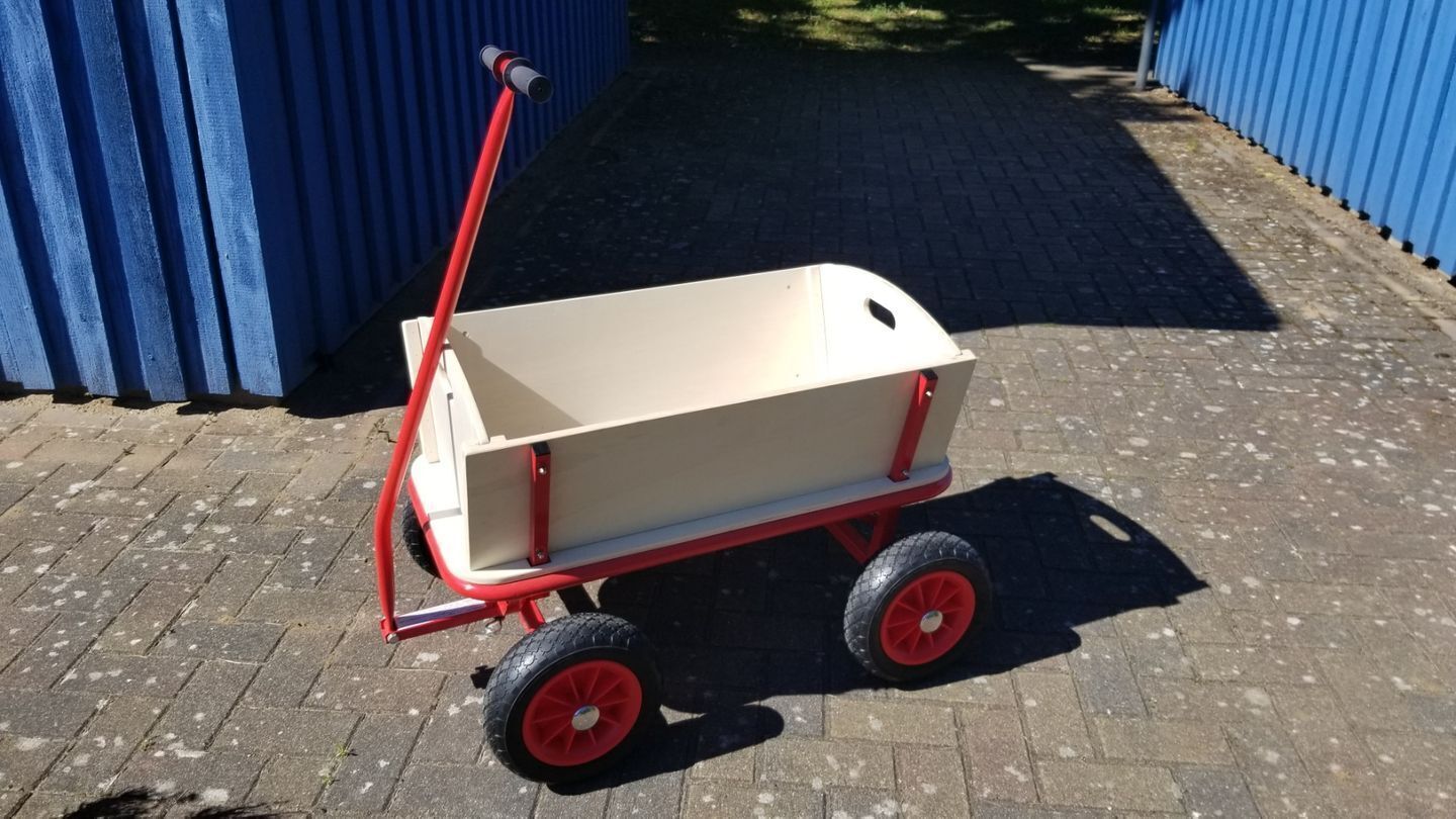 A red and white hand truck with a flatbed, positioned on a paved surface.