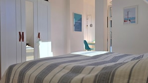 Una camera da letto con un letto, una sedia e un armadio.