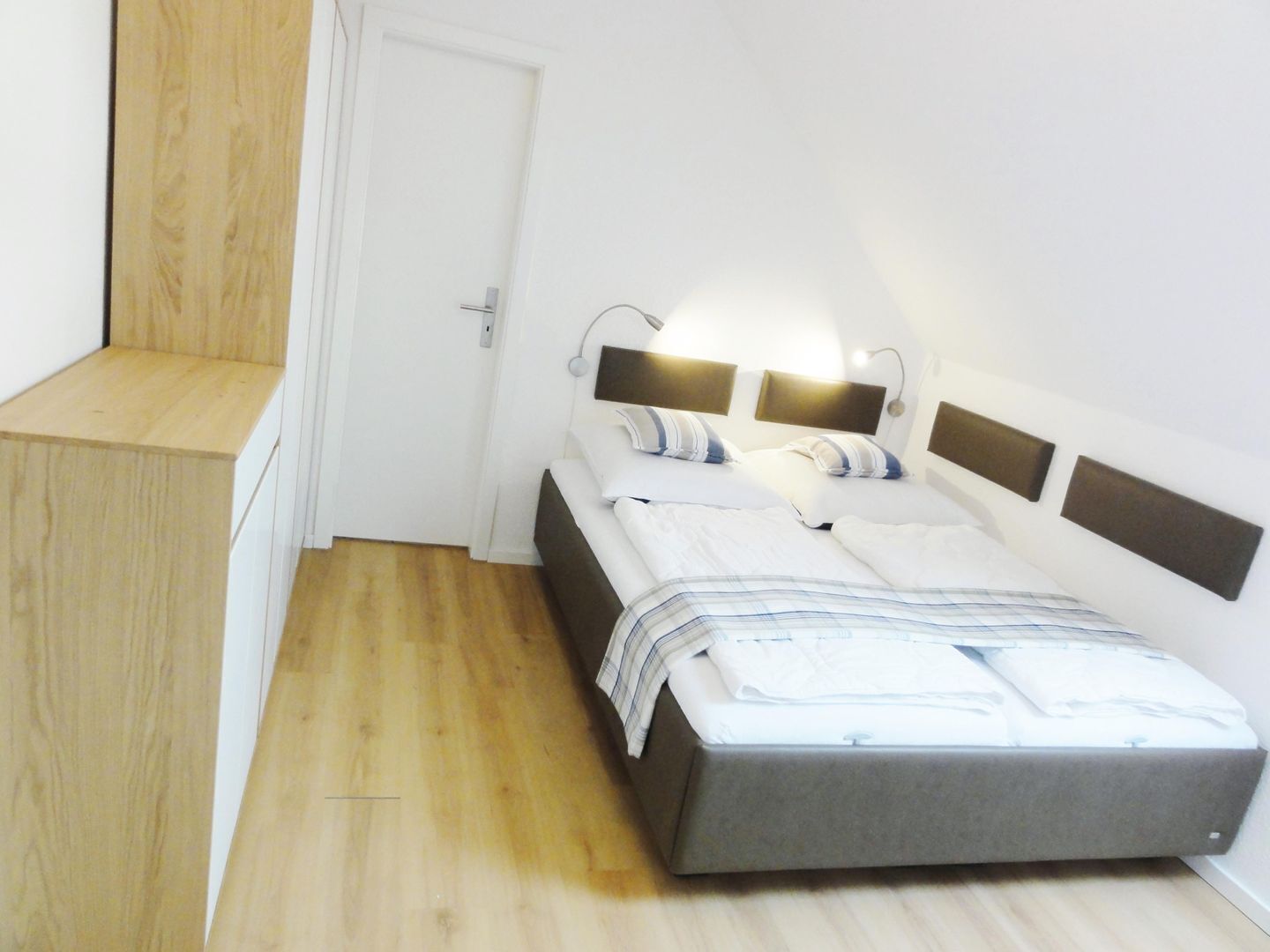 Una camera da letto con un letto, comodini e una porta.