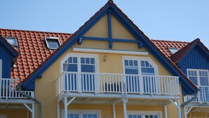 A yellow building with a blue roof and white balconies. - Vacation apartment K38 "Sonnenblume" - 3-room apartment with 2 floors for a maximum of 6 people. (Graal-Müritz)