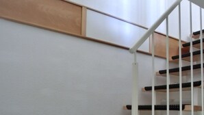 Un escalier moderne avec des marches en bois et une rampe en métal blanc.