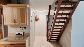 Una cocina con armarios de madera, encimera de granito y un adorno de sol en la pared.