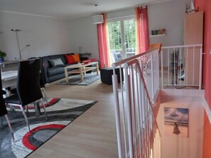 A modern living room with a sofa, coffee table, and a dining area with chairs.