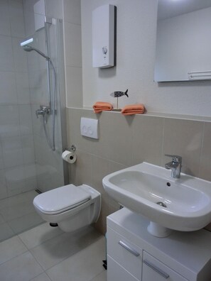 A modern bathroom with a toilet, bidet, and sink.