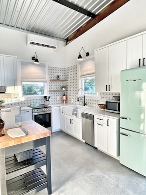 Enjoy cooking in this well-equipped kitchen with a large island, sink, and window.