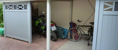 A garage with a motorcycle and a bicycle inside.
