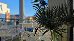 A balcony with white wicker chairs and a potted plant. - Vacation apartment LP14 - 1-room vacation apartment with approx. 19 m² living space and balcony (Graal-Müritz)
