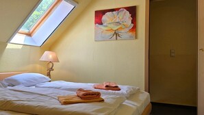 Habitación de hotel con cama, un cuadro, una lámpara y un tragaluz.