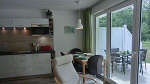 Una cocina moderna con microondas, armarios y un comedor con mesa y sillas.