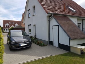 Uma casa moderna de dois andares com um carro estacionado na entrada.