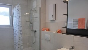 A modern bathroom with a shower, toilet, and sink. - Apartment KWi 77 OG "Windflüchter" - 2-room apartment for 3 persons on the upper floor with (Graal-Müritz)