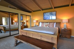 Relax in this serene bedroom with a large bed, bedside tables, and a comfortable bench.