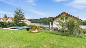 Una propiedad junto al lago con piscina, terraza y vista al lago.