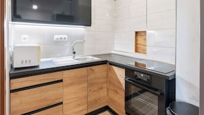 Una cocina moderna con horno empotrado, lavabo y armarios de madera.