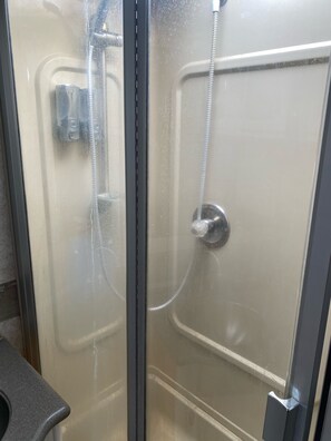 Een douche, handdoeken, zeep, shampoo