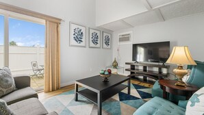 A living room with a sofa, a coffee table, a TV, and a lamp. There are three framed pictures on the wall. - Cozy newly remodeled home close to major amenities  in Connecticut a (Middletown)