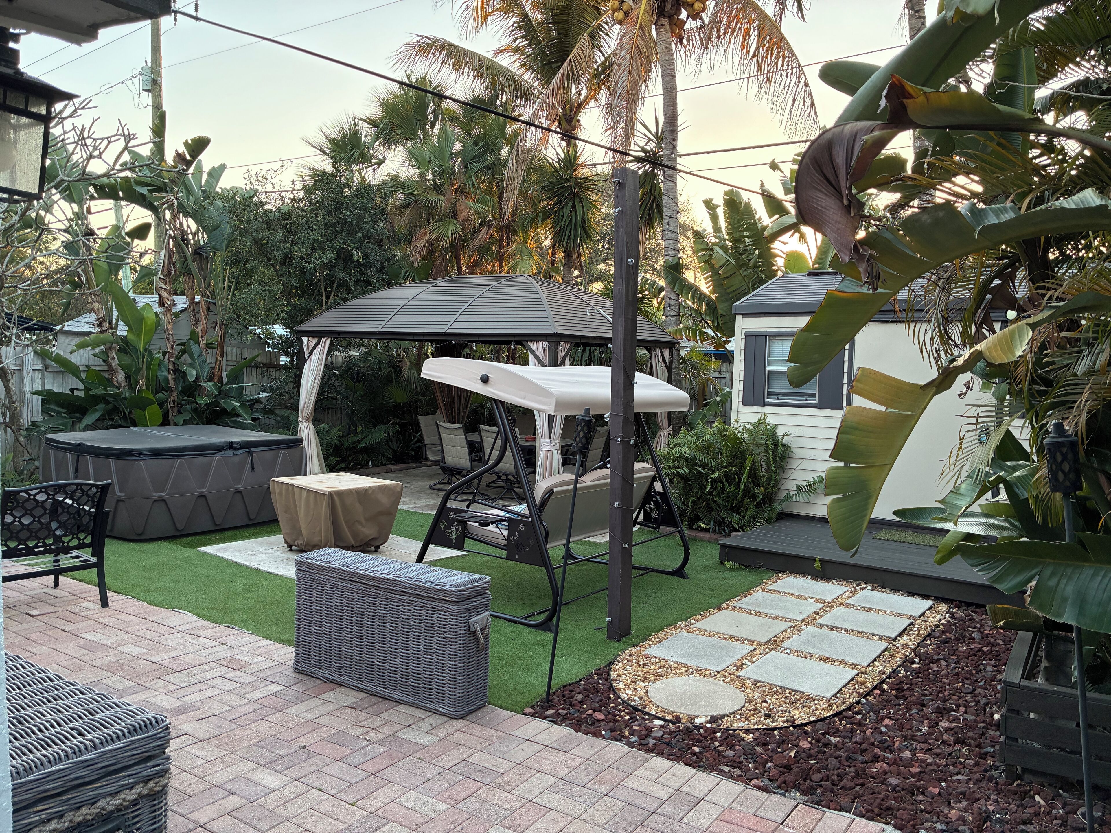 A patio area with a covered seating area, outdoor furniture, and a decorative stone pathway.