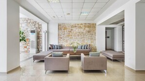A modern lobby with a stone wall, a sofa set, and a coffee table.