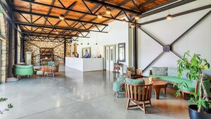 A spacious lobby with a high ceiling, exposed beams, and a reception desk.
