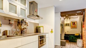 A modern kitchen with a central island, built-in oven, and stainless steel appliances.