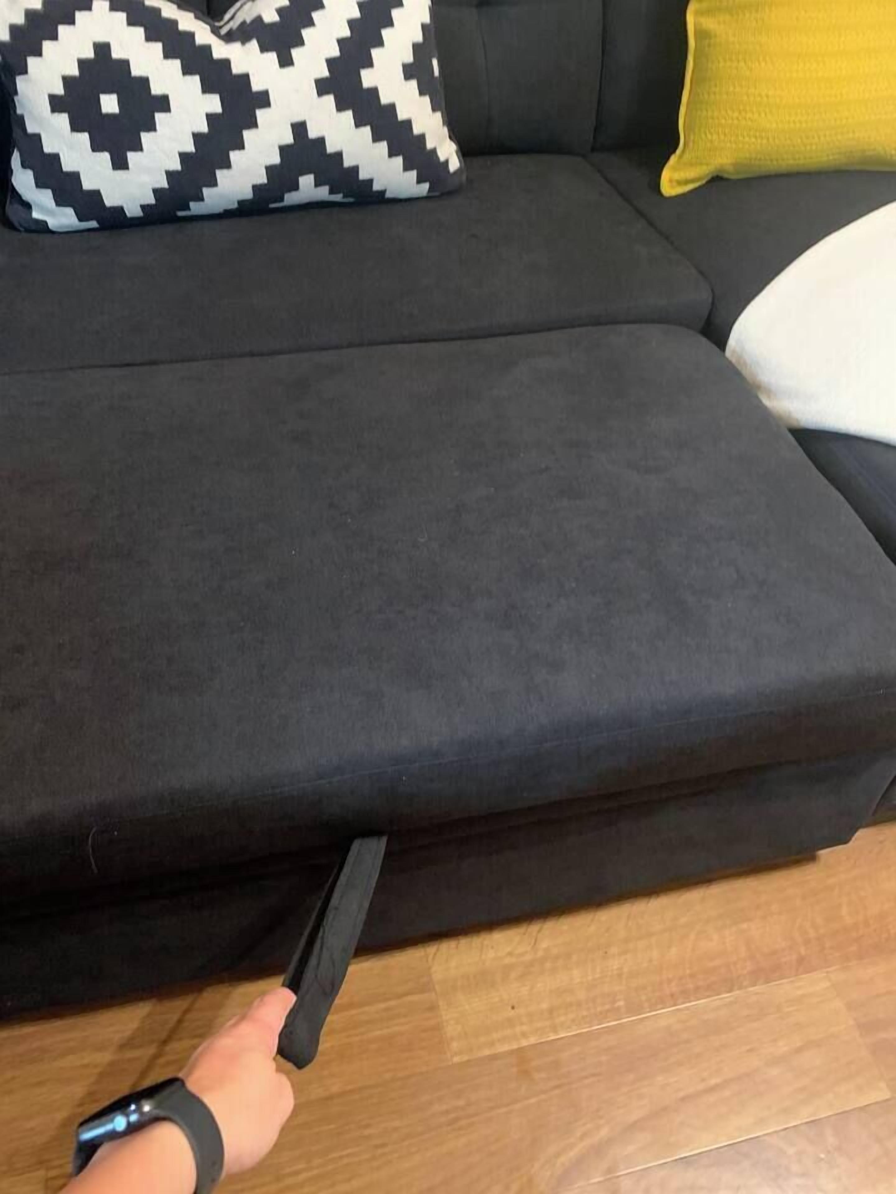 Parte de un sofá con un cojín estampado en blanco y negro y un cojín amarillo.