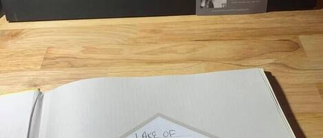 An open book with a handwritten note on the page that reads "Lake of Egypt Tiny Cabin."