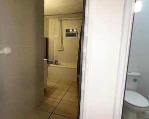 Bathtub, hair dryer, towels, toilet paper