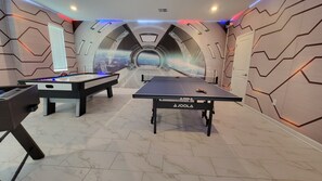 Relax and play in this modern recreational room featuring a foosball table and ping pong table.