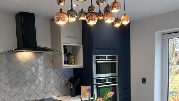 A modern kitchen with a central island, a built-in oven, and a pendant light fixture. - Stylish, Dog Friendly Coastal Bungalow With Garden (Holyhead)