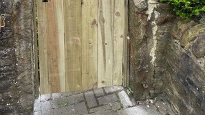 A wooden gate with a sign for Acacia House, a stone wall, and a building with a tiled roof. - Acacia House  - Holiday Cottage Wolsingham (Wolsingham)