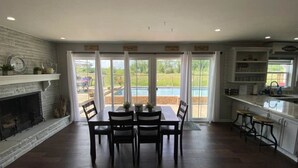 Une cuisine spacieuse avec un coin repas, une cheminée et une vue sur une piscine.