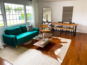 Relax in this inviting living space with a sofa, dining table, and rug.
