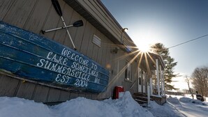En træbygning med et skilt, der skriver "Welcome to Lake Summersville, Est. 2004".