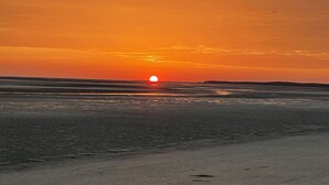 A sunset over a beach with a calm sea and a clear sky. - Apartment with direct view of the Bay of the Somme (Le Crotoy)
