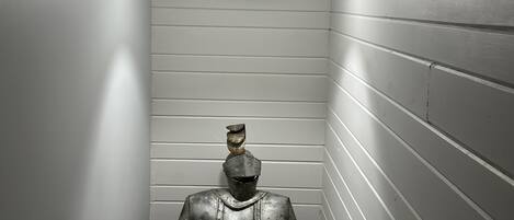 A narrow hallway with white walls and a single light fixture.