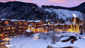 Un complexe hôtelier comprenant plusieurs bâtiments, une piste de ski et un paysage enneigé.