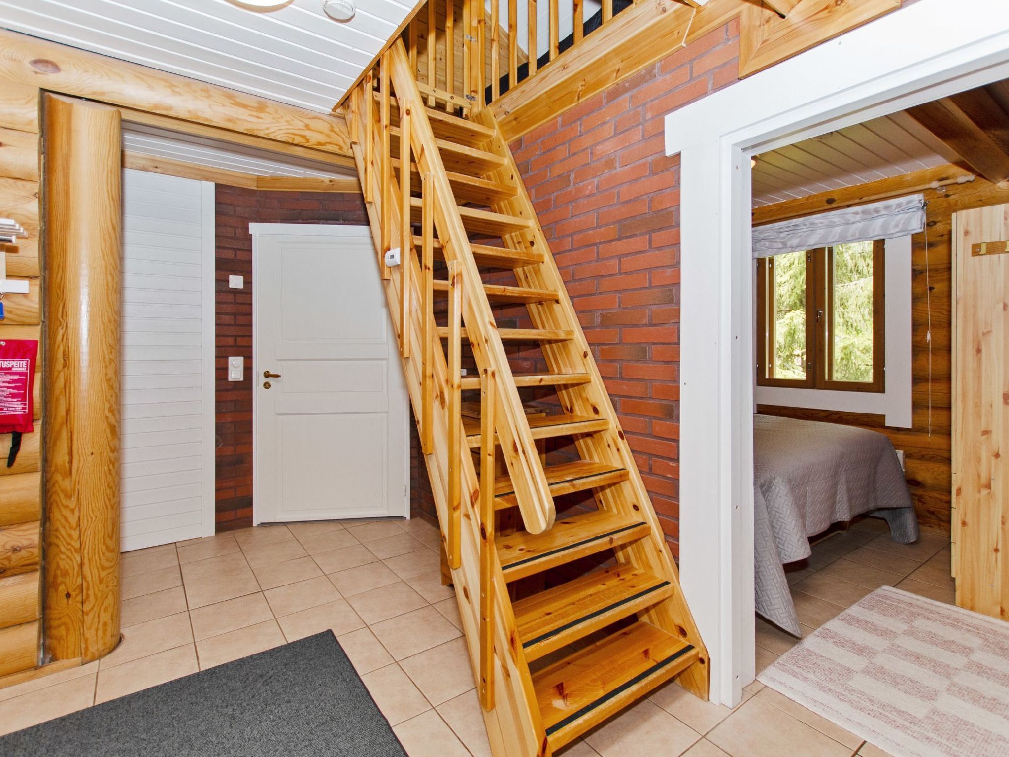 Eine Holztreppe führt zu einem Schlafzimmer mit Schrankraum und einem Fenster.