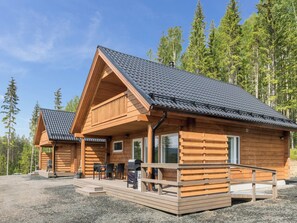 Eine Holzhütte mit Veranda und Sitzgelegenheit im Freien.