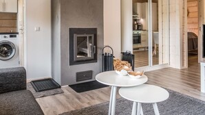 Ein modernes Wohnzimmer mit Kamin, Waschmaschine und Essbereich mit Tisch und Stühlen.