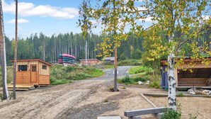 Ein rustikaler Häuserbereich mit einem Feldweg, der zu einem Holzsteg führt.