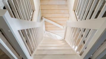 A wooden staircase with white railings leading to a landing.