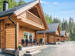 A wooden cabin with a porch, outdoor seating, and a gravel driveway. - Kolin kangastus apila 1 by Interhome (Lieksa)
